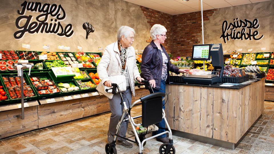 BBG eG – Dame begleitet Dame mit Rollator beim Einkauf