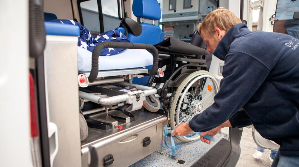 ASB Wünschewagen – Mitarbeite schnallt Rollstuhl im Wagen fest