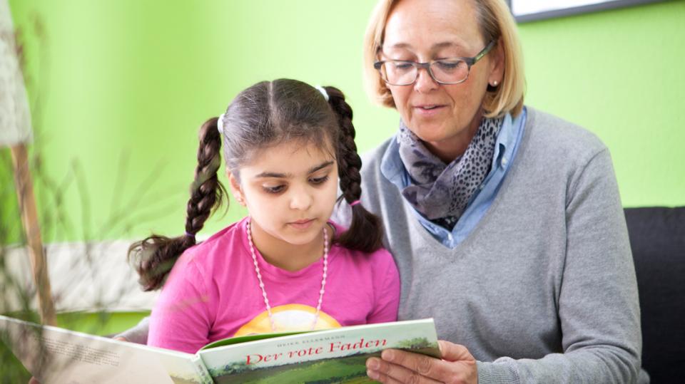 Generationen Hand in Hand – Mädchen und Frau lesen gemeinsam