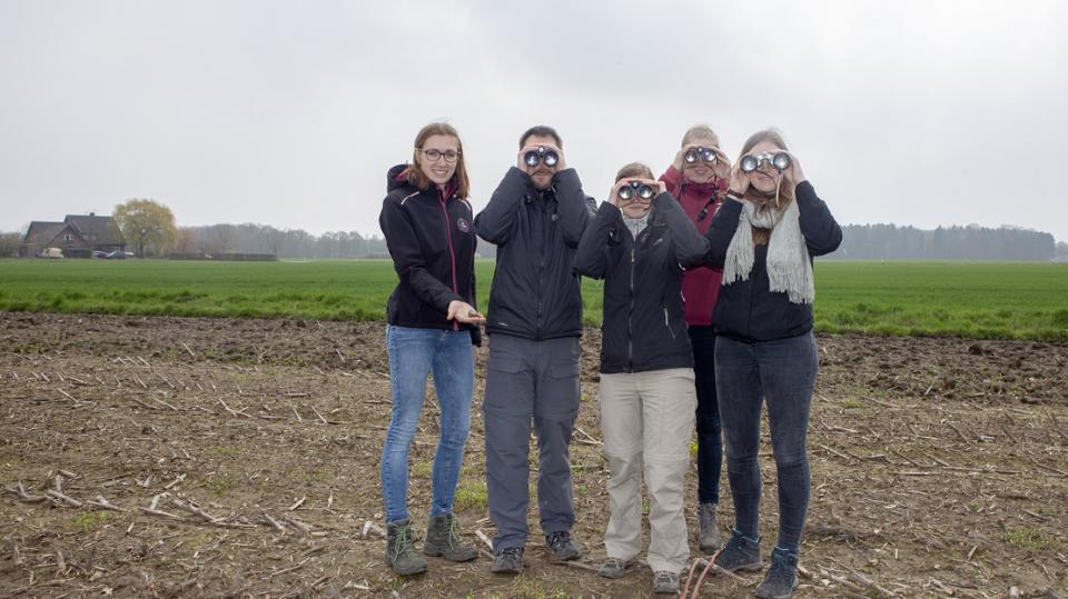 Nabu Münster: Team mit Ferngläsern auf Feld