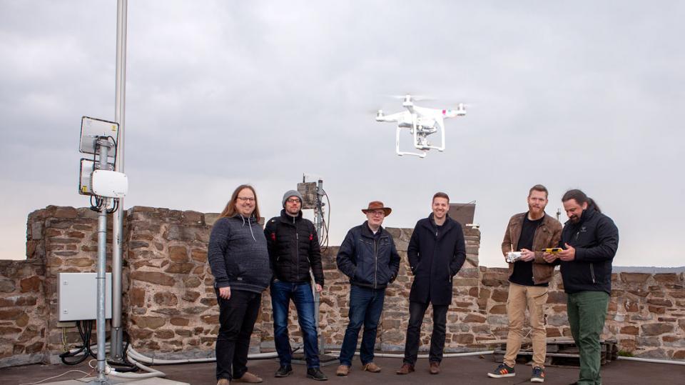 Freie Netzwerker e.V.: Team mit fliegender Drohne und Messgerät auf Turm