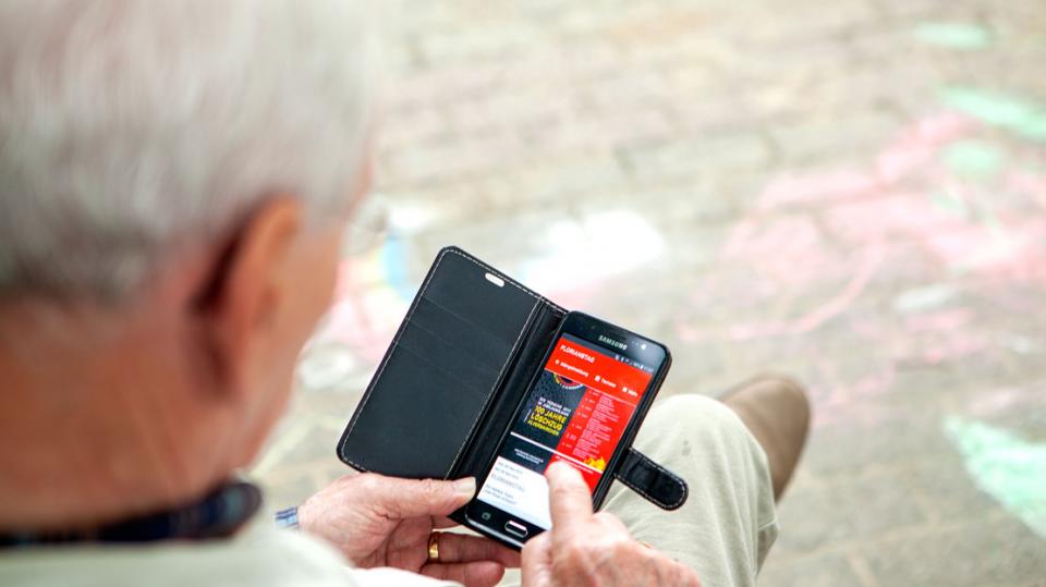 Everswinkel: Älterer Mann nutzt sein Smartphone auf Bank 