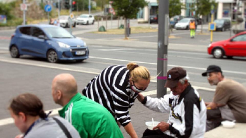 Eine Frau verteilt Essen an obdachlose Menschen