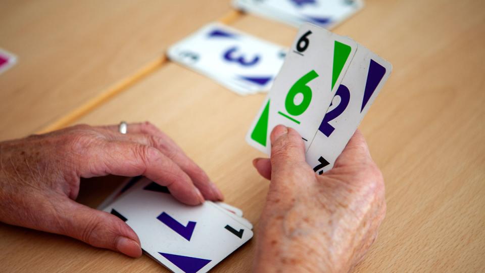 Nahaufnahme der Hände einer Person, die Spielkarten hält
