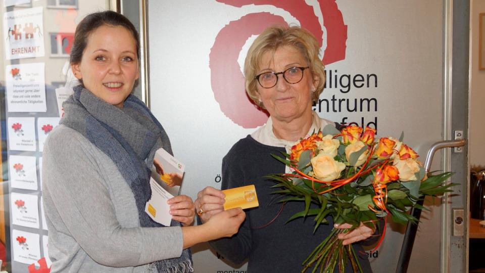 Zwei Frauen halten zusammen die Ehrenamtskarte NRW