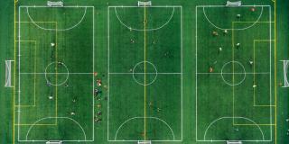 Ein mit Linien in drei Felder unterteilter Fußballplatz aus der Vogelansicht.