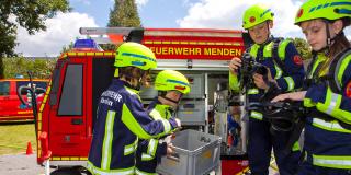 Kinder in Feuerwehruniform am Mini-Löschfahrzeug