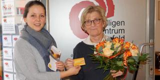 Zwei Frauen halten zusammen die Ehrenamtskarte NRW